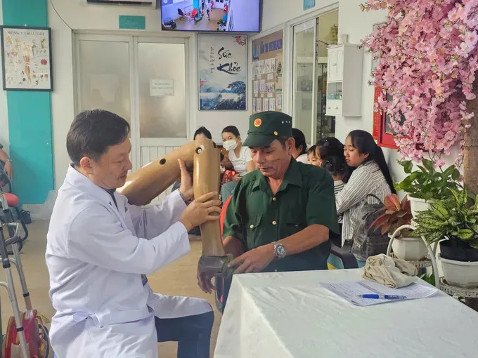 Bác sĩ Huỳnh Văn Phi thăm khám cho thương binh Trần Văn Dũng